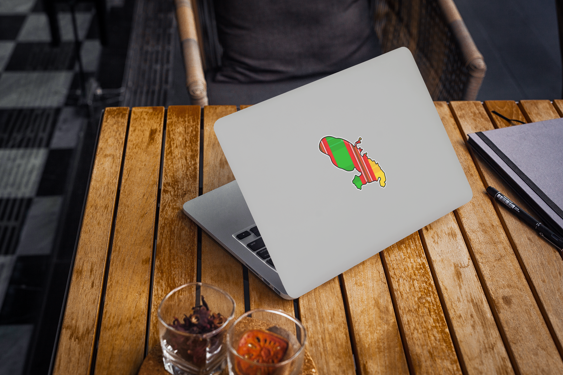 Autocollant en papier Île de la Martinique avec motif madras traditionnel, posé sur un ordinateur portable sur une table en bois.