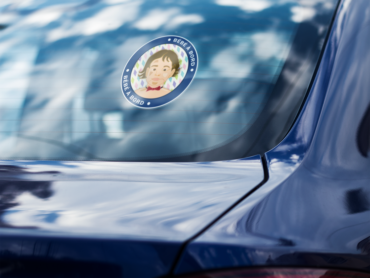 Autocollant "Bébé à bord Léo" de Prodigi sur la vitre arrière d'une voiture bleue.