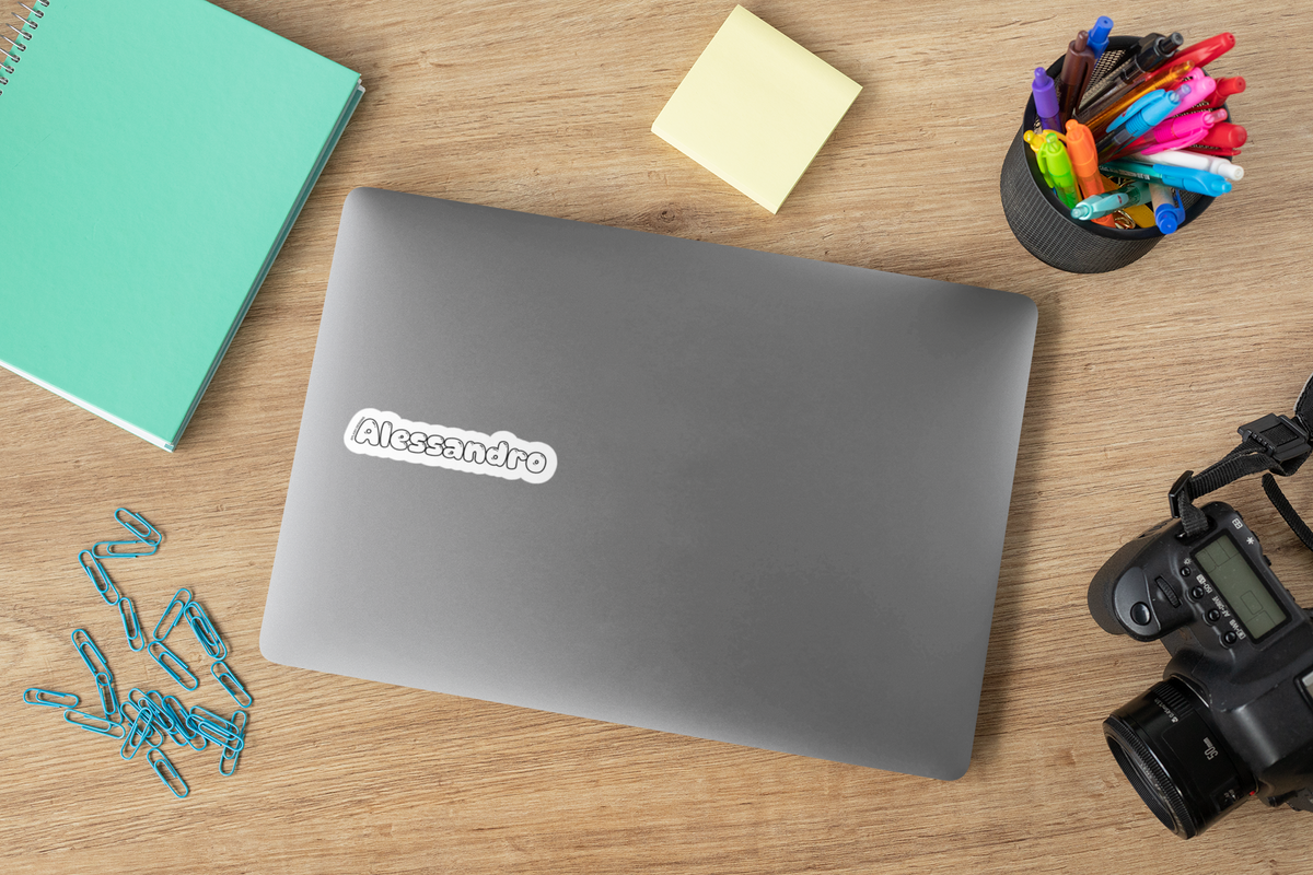 Autocollant personnalisé Prodigi avec votre prénom sur un ordinateur portable, entouré de fournitures de bureau.