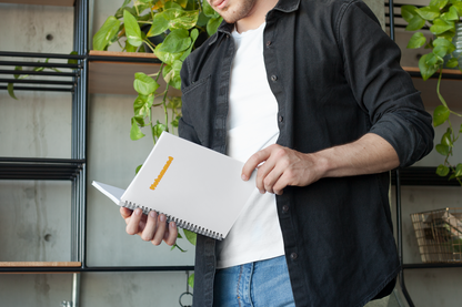Autocollant personnalisé avec prénom unique de la marque Prodigi, affiché sur un carnet avec un homme en chemise noire.