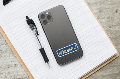 Autocollant "Wesh!" de Prodigi, sticker coloré affiché sur un téléphone avec des fournitures de bureau.