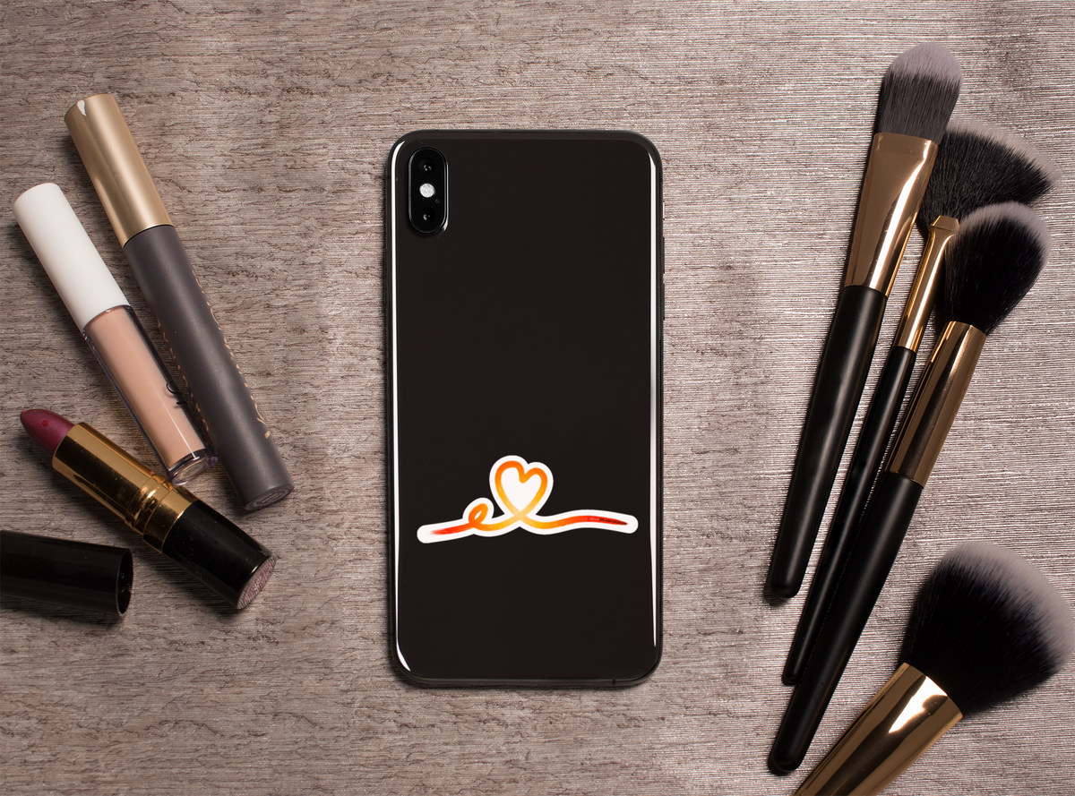Autocollant Coeur tracé rose de la marque Prodigi, représentant un cœur stylisé, sur un fond avec outils de maquillage.