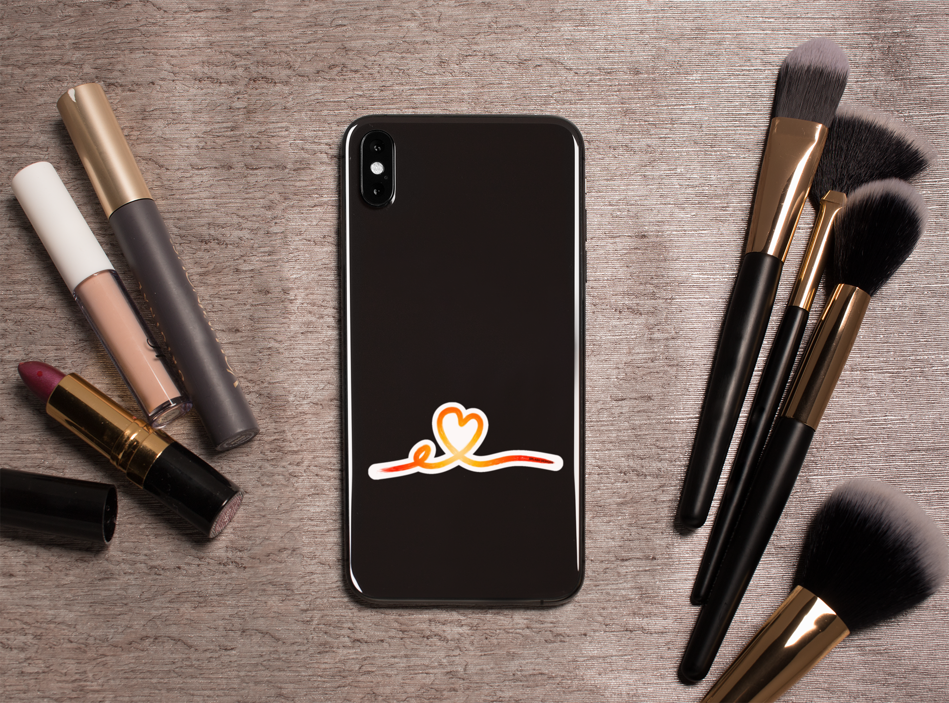Autocollant Coeur tracé rose de la marque Prodigi, représentant un cœur stylisé, sur un fond avec outils de maquillage.