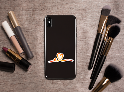 Autocollant Coeur tracé rose de la marque Prodigi, représentant un cœur stylisé, sur un fond avec outils de maquillage.